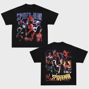 May include: Two black t-shirts featuring Spider-Man graphics. One shirt displays "SPIDER-MAN" in blue lettering with various Spider-Man images. The other shirt has "SPIDERMAN" in yellow and red lettering.