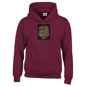 Peut inclure: Un sweat-shirt à capuche bordeaux avec une impression graphique centrale portant le texte "POLY KIDS BUILT DIFFERENT" dans une police décorative beige. Le motif inclut des illustrations de trois enfants et des détails floraux.