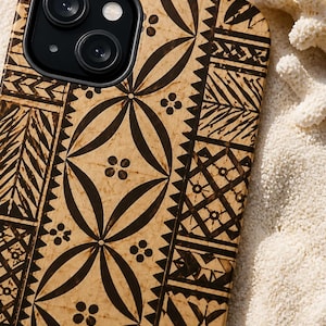 May include: A tan smartphone case featuring a dark brown geometric pattern with repeating circular motifs, leaf-like shapes, and triangular borders. The case has a cutout for a dual-lens camera system and a flash, showcasing a flat, textured surface.