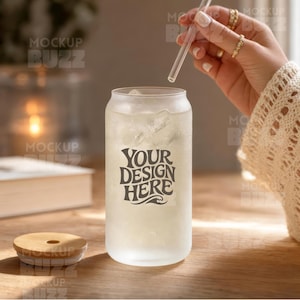 Puede incluir: Un vaso esmerilado con forma de lata lleno de hielo, con el texto oscuro "YOUR DESIGN HERE" en una fuente ondulada. El vaso incluye una pajita de vidrio transparente y una tapa redonda de bambú con un orificio central para la pajita.
