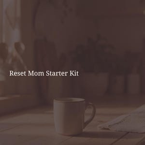 Könnte beinhalten: Eine schlichte weiße Keramiktasse steht auf einer Holzoberfläche. Der Text Reset Mom Starter Kit ist in Weiß im oberen Teil des Bildes aufgedruckt. Die Farbpalette ist gedämpft mit einem dunkelbraunen Overlay, was ein weiches Aussehen erzeugt.
