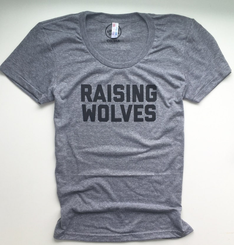 May include: A heather grey t-shirt with a black graphic that says "Raising Wolves".