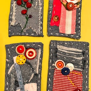 May include: Four denim fabric art pieces with decorative stitching and embellishments. Each piece features unique designs, including ladybugs, striped fabric, buttons, and gingham patterns. The backgrounds are yellow.