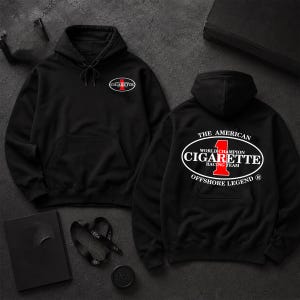 May include: A black hooded sweatshirt featuring a front graphic with a red number one and the text CIGARETTE. The back displays a large oval logo with the text THE AMERICAN, CIGARETTE, WORLD CHAMPION RACING TEAM, and OFFSHORE LEGEND with a red number one.