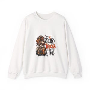 May include: A white long-sleeve sweatshirt featuring a graphic of a skeleton with a messy bun, leopard print headband, and heart-shaped sunglasses, holding a pumpkin drink. The text reads Zero Tricks To Give in orange and black.