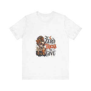 Puede incluir: Una camiseta blanca de manga corta con un gráfico de un esqueleto con un moño, gafas de sol en forma de corazón y una diadema de leopardo, sosteniendo una bebida de calabaza, con el texto ZERO TRICKS TO GIVE en naranja y negro.