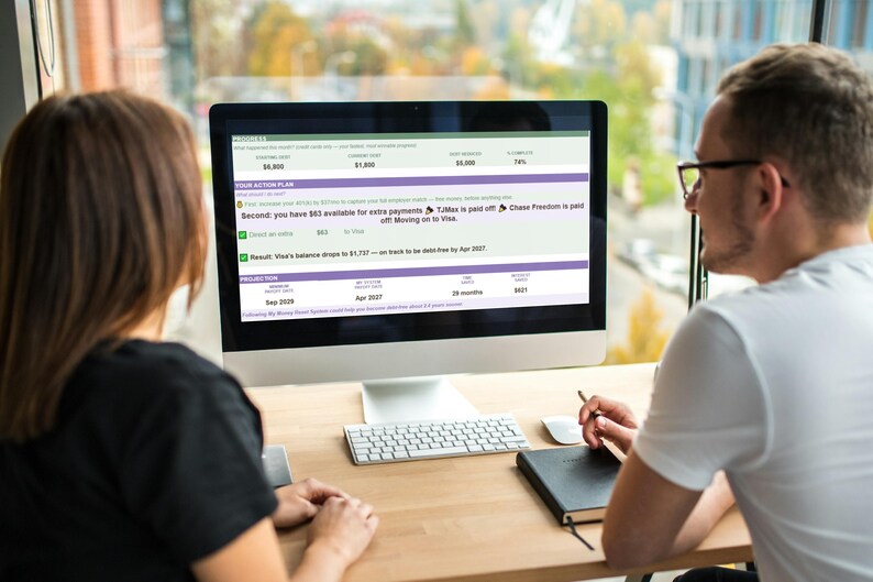 May include: A computer monitor displaying a financial debt repayment plan dashboard with progress bars, action items, and projections. The screen shows text including 'PROGRESS', 'YOUR ACTION PLAN', and 'PROJECTION' with various data points and dates.