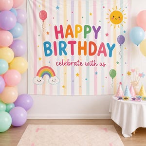 May include: A rectangular fabric backdrop featuring vertical pastel stripes and the text HAPPY BIRTHDAY celebrate with us. The design includes a smiling yellow sun, a colorful rainbow with clouds, and various balloons and stars in bright colors.