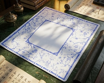 May include: A square white mat featuring a blue ink illustration of bamboo stalks forming a border, with intricate drawings of birds, flowers, and small pagodas filling the space between the bamboo lines, creating a detailed decorative pattern.