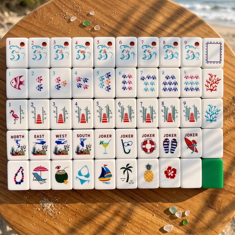 Op de afbeelding: Een complete set witte Mahjong-tegels met kleurrijke illustraties. De tegels tonen diverse ontwerpen, waaronder vissen, bloemen en tropische afbeeldingen. De set bevat tegels met nummers, richtingen en Jokers, perfect voor een spelletje Mahjong.