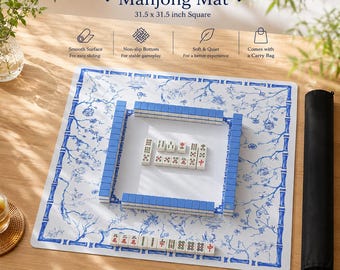 May include: A square 31.5 x 31.5 inch Mahjong mat featuring a white surface with a blue floral and bamboo border pattern. The mat displays Mahjong tiles arranged in a square formation and a separate row of tiles, accompanied by a black carry bag.
