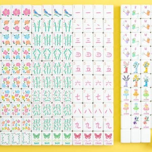 May include: A complete set of white Mahjong tiles with colorful floral, bird, and bamboo designs. The tiles feature numbers, Chinese characters, and suit symbols. The set includes tiles with butterflies and the word "Joker".