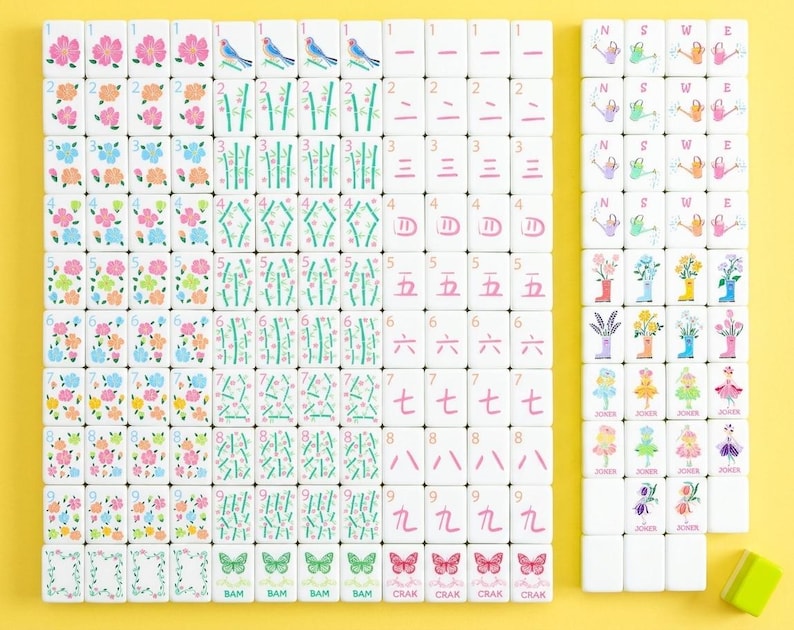 May include: A complete set of white Mahjong tiles with colorful floral, bird, and bamboo designs. The tiles feature numbers, Chinese characters, and suit symbols. The set includes tiles with butterflies and the word "Joker".