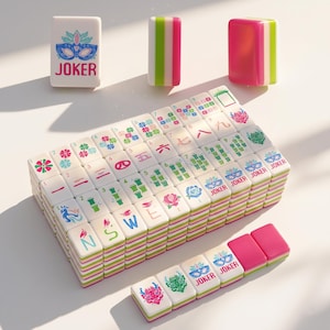 May include: A set of white and pink Mahjong tiles with green and pink striped edges. The tiles feature various symbols, numbers, and the word "JOKER". Some tiles have floral and mask designs. The game pieces are stacked and arranged on a white surface.