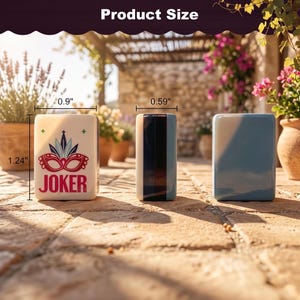 May include: Three ceramic rectangular containers. The first is off-white with a red and blue mask design and the word "JOKER". The second is a vertical rectangle with black, white, and blue stripes. The third is solid light blue. The first is 1.24" tall and 0.9" wide.