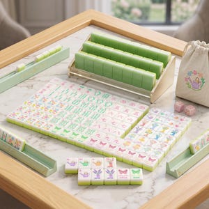 May include: A complete mahjong set with green tiles, a wooden rack, and dice. The tiles feature colorful floral and butterfly designs. A small drawstring bag with a floral watering can design is also included.