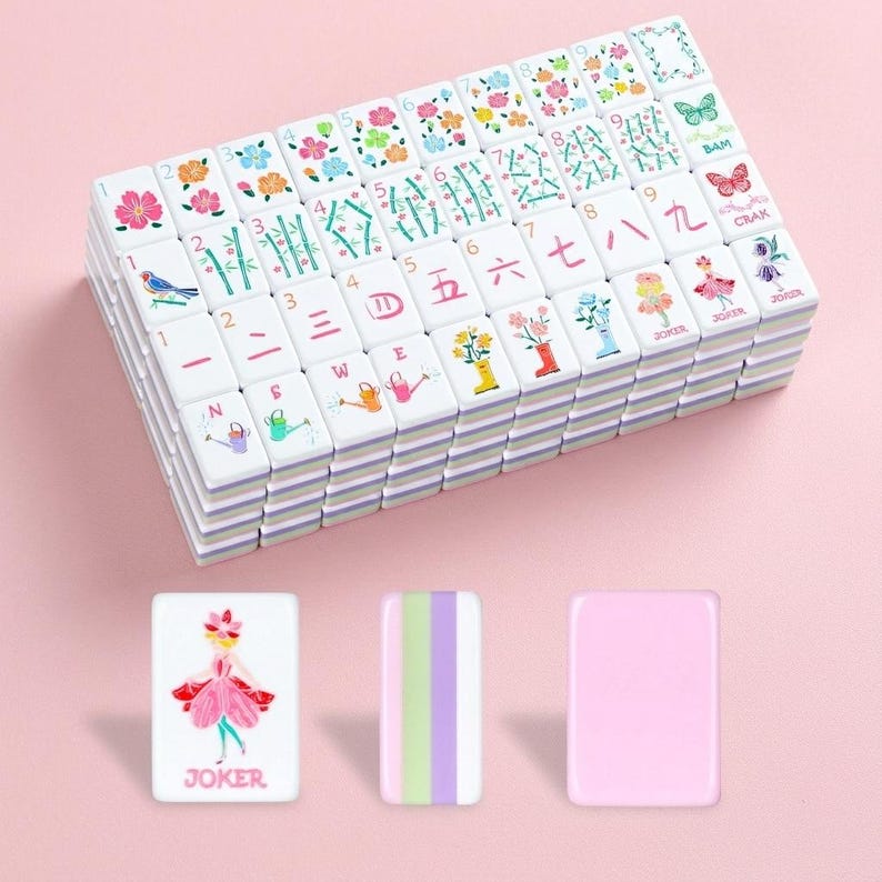 May include: A stack of white Mahjong tiles with colorful illustrations and Chinese characters. The tiles feature floral designs, birds, and numbers. Three additional tiles are displayed, including a "JOKER" tile and a striped tile.