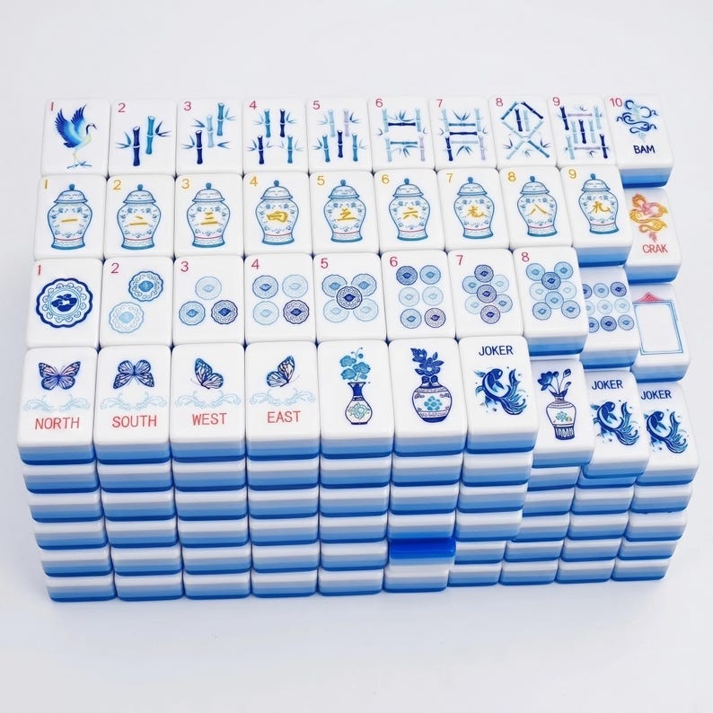 Puede incluir: Un juego completo de fichas de Mahjong. Las fichas blancas presentan ilustraciones azules y blancas de p&aacute;jaros, bamb&uacute;, jarrones y mariposas. El juego incluye fichas numeradas, direccionales y "Joker".