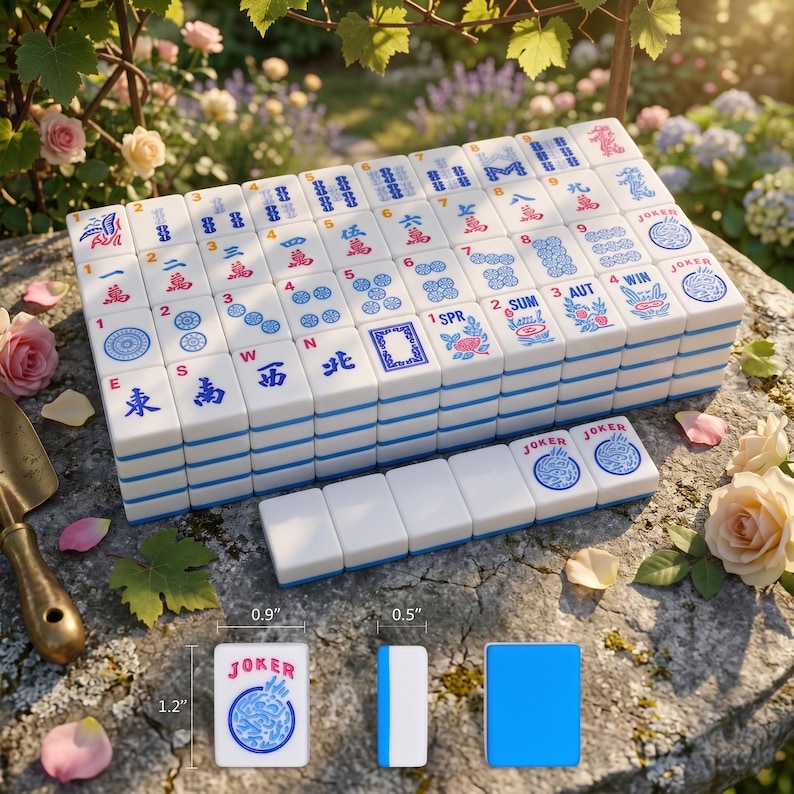 K&ouml;nnte beinhalten: Ein komplettes Mahjong-Set mit wei&szlig;en Spielsteinen mit blauen und roten Symbolen und Schriftzeichen. Die Spielsteine sind auf einer Steinoberfl&auml;che gestapelt, einige Spielsteine sind ausgelegt. Ein Spielstein zeigt "JOKER". Das Set enth&auml;lt einen blauen Spielstein.