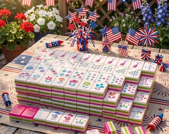 May include: A Mahjong set with white tiles featuring colorful floral and geometric designs. The tiles are stacked on a table decorated with American flags and festive decorations, perfect for a patriotic game night.