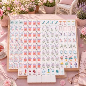 Puede incluir: Un juego de fichas de mahjong con piezas blancas que presentan ilustraciones coloridas, incluyendo ramas de lavanda, jarrones con flores, regalos y varios iconos. Las fichas est&aacute;n dispuestas en una cuadr&iacute;cula sobre un tablero de madera.