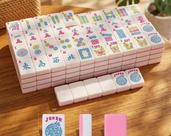 May include: A set of white Mahjong tiles with pink backs and colorful engraved symbols, including numbers, characters, and Joker tiles. The tiles measure 1.2 inches by 0.9 inches by 0.5 inches as indicated by the visible measurement labels.