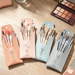 Op de afbeelding: Vier rechthoekige make-up kwastenetuis in perzik, lichtroze, lichtblauw en grijs, elk voorzien van een florale lijntekening en de naam Alice. Elk etui bevat een set make-up kwasten met lichtgekleurde haren en metalen handvatten.