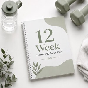 May include: A spiral-bound notebook with the text "12 Week Home Workout Plan" in green. The notebook is next to a water bottle, two 3KG dumbbells, a folded towel, and greenery. The overall color scheme is white and green.