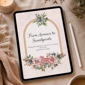 May include: A digital tablet shows a journal cover with the title "From Armour to Sweatpants." The design includes floral and botanical illustrations in pink, green, and blue. A white stylus and a lit candle are also present.