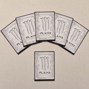 May include: A collection of six trading cards with a black border and white background. The cards feature the text "Plains" at the top and "PLAINS ENERGY" in the center, with a stylized claw mark design. The words "Basic Land - Plains" are at the bottom.