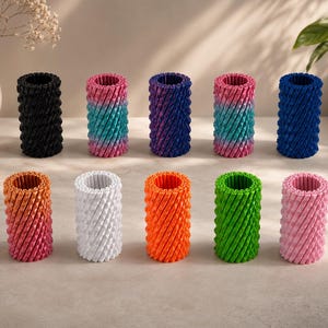 Peut inclure: Dix rouleaux anti-stress cylindriques disposés sur deux rangées. Les rouleaux présentent une surface texturée en spirale et sont disponibles en plusieurs couleurs unies, notamment noir, bleu, blanc, orange, vert, rose et dégradés.