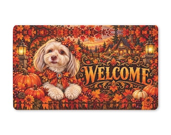 Puede incluir: Un felpudo rectangular que muestra un perro de color claro con una corona de flores y un lazo, rodeado de calabazas naranjas, hojas de otoño y una casa. La palabra WELCOME está impresa en letras grandes, decorativas y de color marrón oscuro.