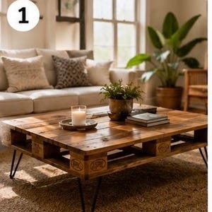 May include: A low-profile coffee table constructed from a wooden shipping pallet with a dark stained finish, featuring four black metal hairpin legs. The table surface holds a white candle in a glass jar, a small potted green plant, and books.