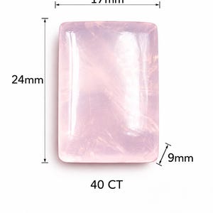 Pode incluir: Uma pedra preciosa de quartzo rosa retangular com uma superfície lisa e polida. A pedra mede 24 mm de altura, 17 mm de largura e 9 mm de profundidade, com um peso de 40 CT. A pedra rosa claro apresenta inclusões naturais internas.