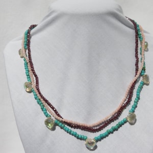 Beautiful multi colored 3 strand necklace, made with turquoise, garnets, citrine and pink coral.