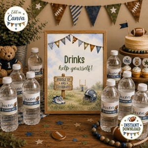 Op de afbeelding: Een ingelijst bord met een football-thema met de tekst Drinks help yourself en Huddle up and celebrate, omringd door doorzichtige plastic waterflessen met labels Jaxon is turning one, een teddybeer en een kleine football-taart.