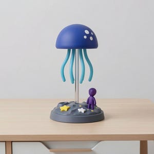 May include: A whimsical blue jellyfish lamp with white dots on the top, supported by light blue tentacles. The lamp sits on a gray base with a purple figurine and star-shaped accents. The lamp is on a wooden surface.