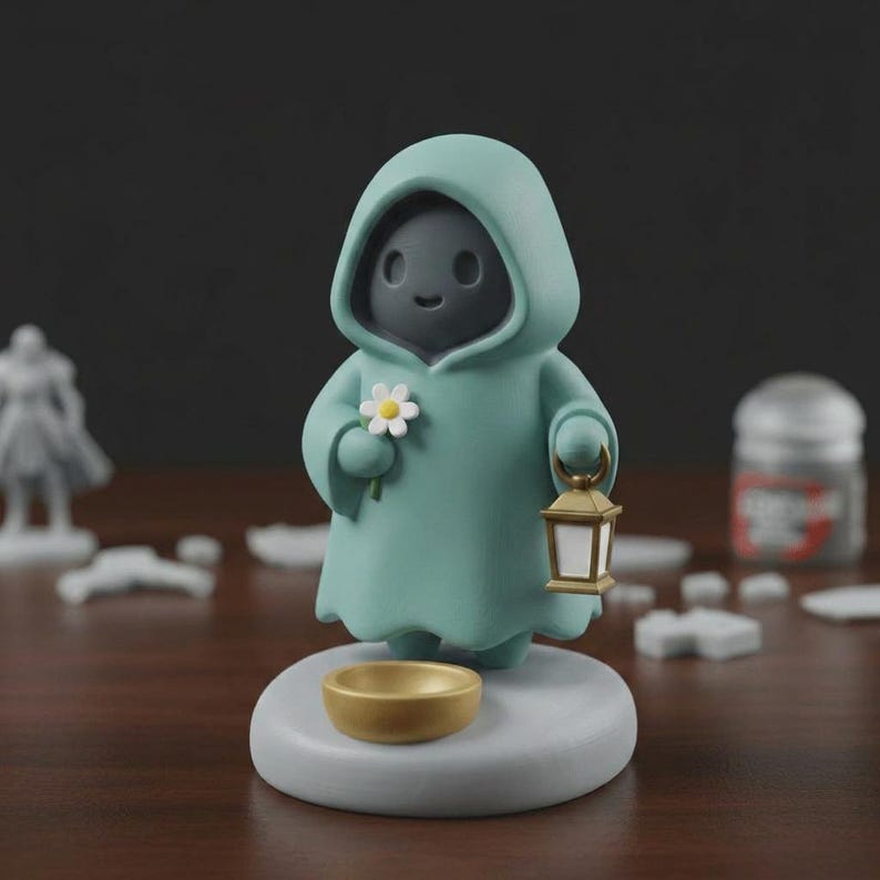 May include: A figurine of a hooded figure in a teal robe, holding a daisy and a lantern. The figure stands on a gray base with a gold bowl. The figure's face is dark gray with a smiling expression. The lantern is gold and white.