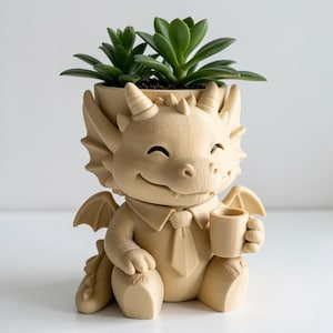 May include: A light beige, 3D-printed dragon planter featuring a smiling dragon wearing a collared shirt and tie while holding a small mug. The dragon has horns, wings, and a tail, with a green succulent plant growing from the top of its head.