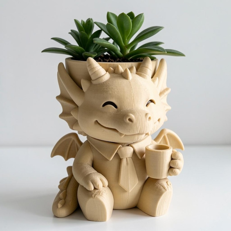 May include: A light beige, 3D-printed dragon planter featuring a smiling dragon wearing a collared shirt and tie while holding a small mug. The dragon has horns, wings, and a tail, with a green succulent plant growing from the top of its head.