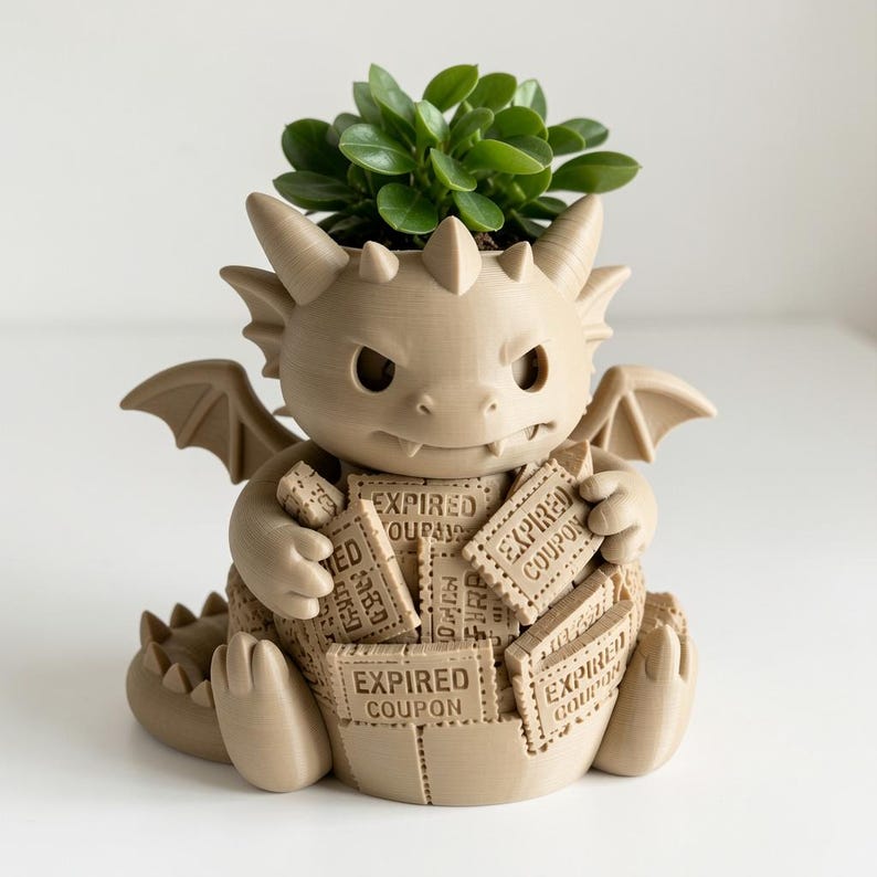 May include: A beige 3D-printed dragon planter featuring a small green succulent plant. The dragon figure has wings, horns, and a tail, and it is holding a collection of rectangular tiles, each clearly embossed with the text EXPIRED COUPON.
