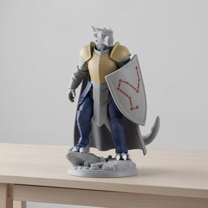 May include: A figurine of a dragon-like humanoid warrior in armor, holding a shield with a red constellation design. The figure is primarily gray, with gold and blue accents. It stands on a rocky base.