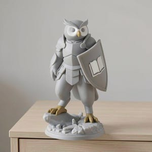 May include: A gray owl figurine in armor, holding a shield with a book emblem. The owl has a yellow beak and feet, standing on a rocky base. The figurine is on a light-colored wooden surface.