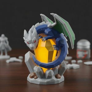 Puede incluir: Una figura geom&eacute;trica de drag&oacute;n en tonos azules, blancos y verdes, posada sobre un cristal amarillo brillante. El drag&oacute;n tiene ojos rojos y est&aacute; rodeado de formaciones rocosas grises. Un art&iacute;culo decorativo de tem&aacute;tica fant&aacute;stica.