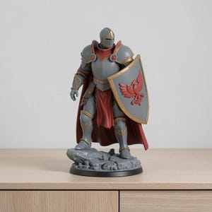 May include: A detailed figurine of a knight in full armor, standing on a rocky base. The knight is clad in gray and gold armor, with a red cape and shield. The shield features a red bird emblem. The figurine is approximately 10 inches tall.