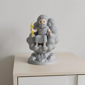 May include: A gray figurine of Zeus, seated on a cloud, holding a yellow lightning bolt. The figurine has a beard and is wearing a toga. The base is a rocky design. The figurine is on a light-colored surface.