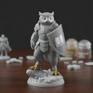 May include: A gray owl figurine in armor, holding a shield with a book emblem. The owl stands on a rocky base, with gold-colored talons. The figurine is a miniature, likely for tabletop gaming or display.