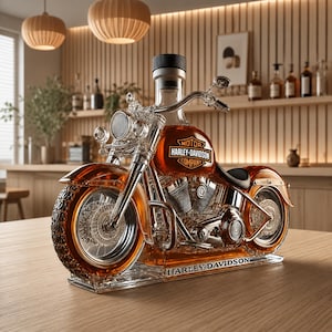 Puede incluir: Un decantador de cristal transparente con forma de motocicleta lleno de líquido ámbar. El depósito de combustible lleva el logotipo de Harley-Davidson y la base tiene grabada la inscripción Harley-Davidson. Tiene un tapón negro.