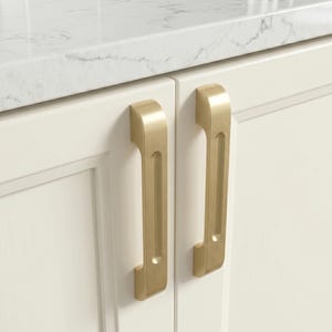 Puede incluir: Dos tiradores de armario de latón cepillado con un diseño rectangular vertical y un canal central empotrado. Estos tiradores de metal están montados en puertas de armario de color blanco roto, con un acabado metálico mate y liso.