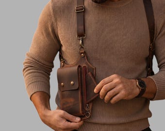 May include: A dark brown leather holster bag featuring a rectangular main compartment with a flap closure secured by two metal snaps, an attached side pocket, and adjustable leather shoulder straps with metal buckles and swivel clips.